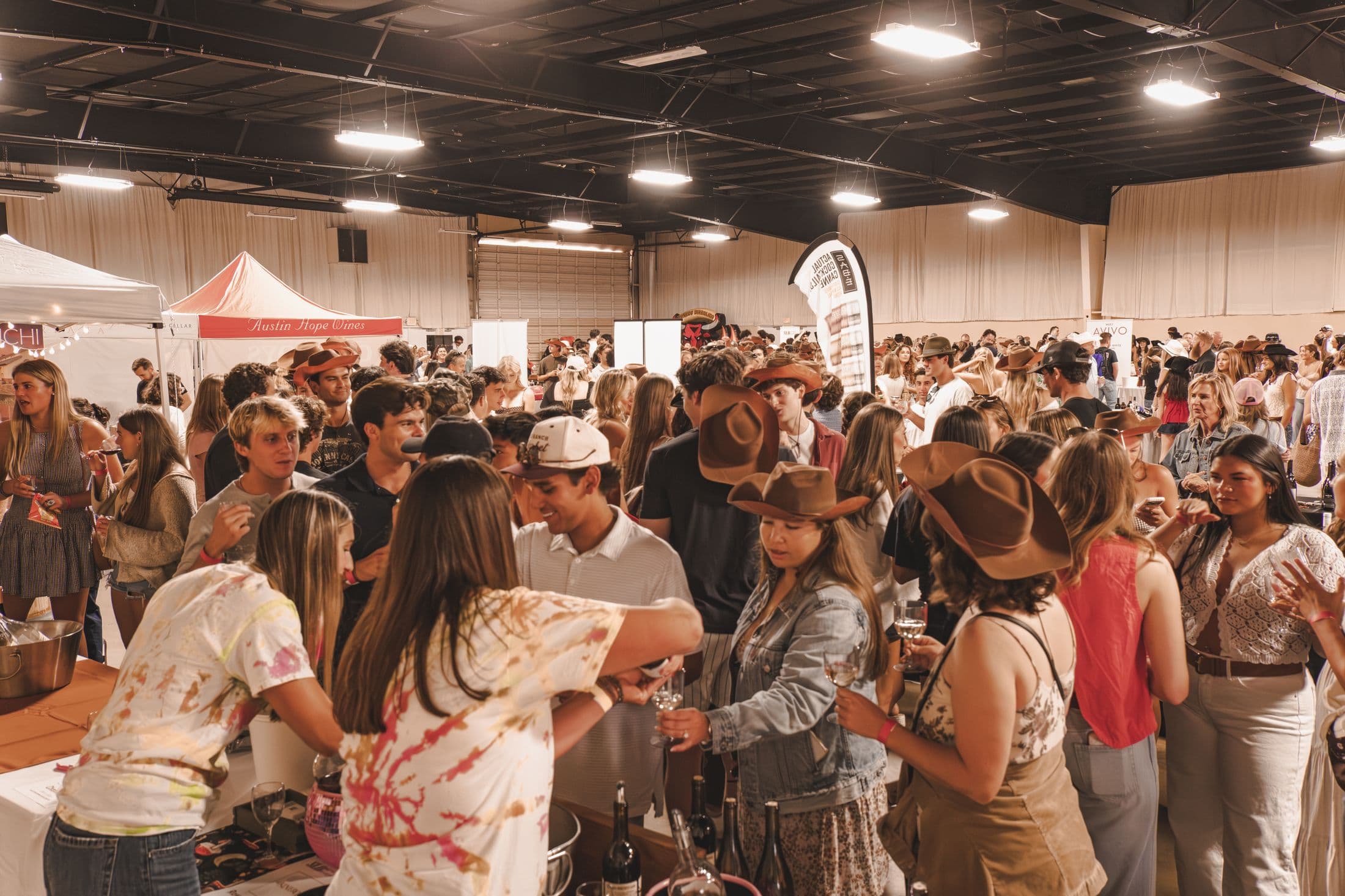 A full room of guests at winery booths during the SLO Wine Mixer